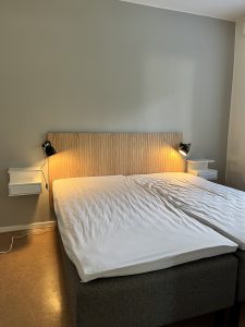Dubbelsäng med sänggavel i trä.