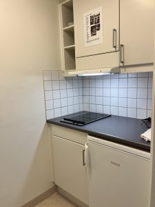 Kök med spishäll och köksskåp.