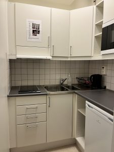 Kök med diskbänk, spishäll och köksluckor. 
