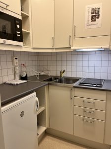 Kök med diskbänk, spishäll och köksinredning.