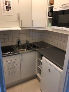 Kök med vask, spishäll och köksinredning. 