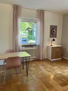 Vardagsrum med bord och två stolar.