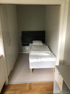 Sovrum med lampa och sängbord. 