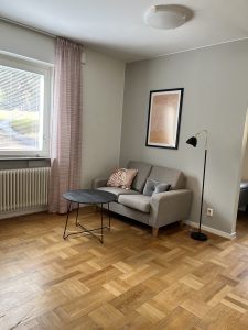 Vardagsrum med soffa, soffbord och lampa