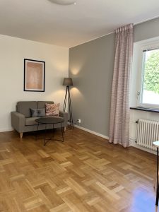 Vardagsrum med soffa och lampa.