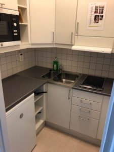 Kök med arbetsytor, skåp och vask.