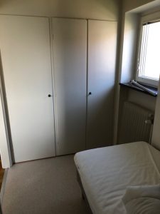 Säng, fönster och garderober.