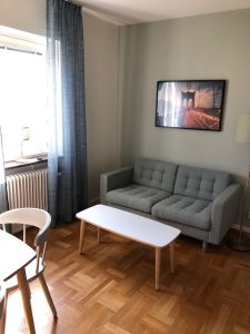 Soffa, bord, fönster och tavla.